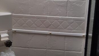 Fifth wheel shower wall repair showing holes where rivets were broken